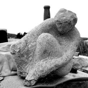 Sitzende menschliche Figur in Bewegung