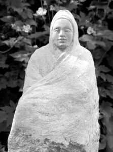 Sitzender Mensch in sein Gewand gehüllt