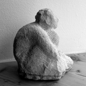 Kleine sitzende Figur, das Knie umschlungen