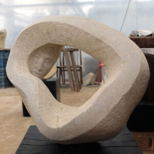 Ein Menschenkopf schaut durch einen Steinring