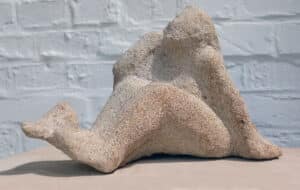 Sandsteinfigur mit Blick in den Himmel und Vogel auf dem Fuss