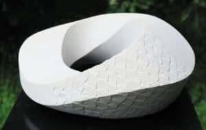 Möbiusband aus Sandstein mit gemeißelter Schuppen Struktur