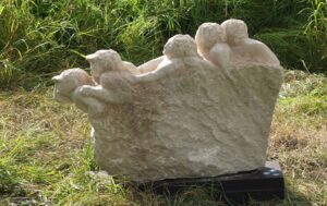 Weiße Steinskulptur: Fünf Menschen aus einem Block gearbeitet, stehen hintereinander und entdecken das was vor ihnen liegt.