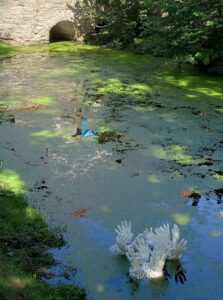 Gips-Porenbeton Skulptur: mehrere, zusammenhängende Hände strecken aus dem See